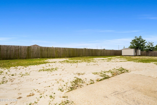 view of yard featuring a storage unit, an outdoor structure, and a fenced backyard