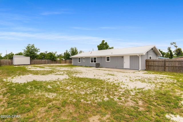 rear view of property featuring a shed, a patio, a fenced backyard, and an outdoor structure