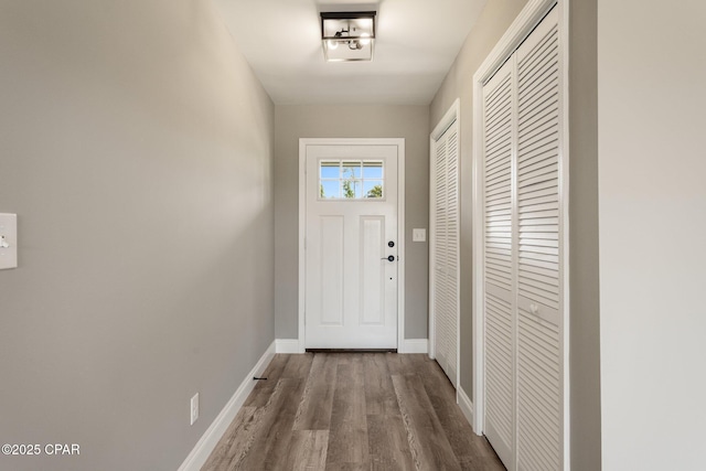 doorway with wood finished floors and baseboards