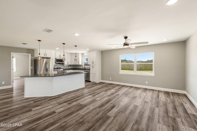 kitchen with visible vents, decorative backsplash, appliances with stainless steel finishes, a center island, and white cabinetry