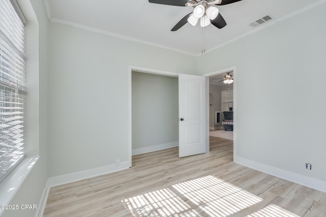 spare room with ornamental molding, ceiling fan, and light wood-type flooring