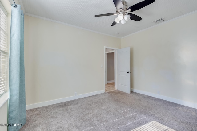 carpeted empty room featuring ceiling fan and crown molding