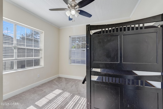 interior space featuring light colored carpet, ceiling fan, ornamental molding, and a wealth of natural light