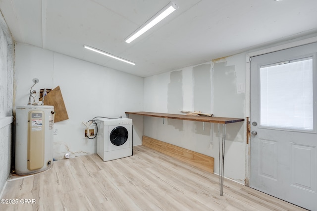 laundry room featuring water heater, washer / clothes dryer, and light hardwood / wood-style flooring