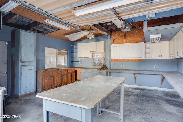 kitchen featuring a kitchen island, white cabinetry, ceiling fan, and a kitchen bar