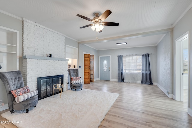 living room featuring ceiling fan, light hardwood / wood-style flooring, ornamental molding, and a fireplace