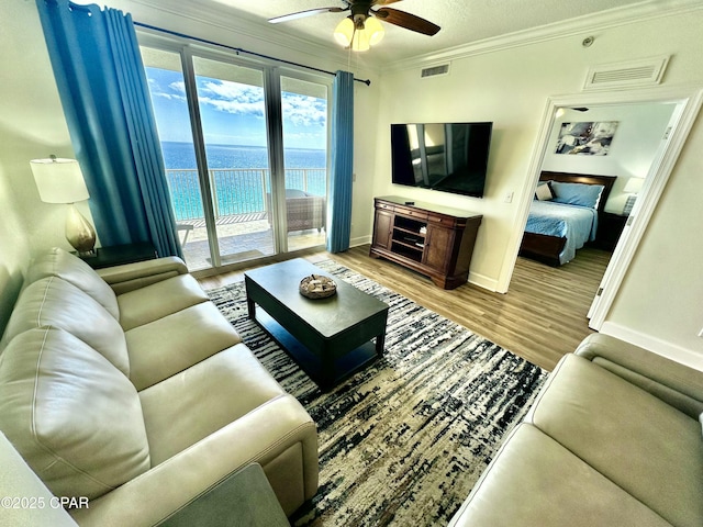 17643 Front Beach Rd Unit 1806, Panama City Beach, FL 32413 - living room featuring visible vents, baseboards, a ceiling fan, wood finished floors, and crown molding