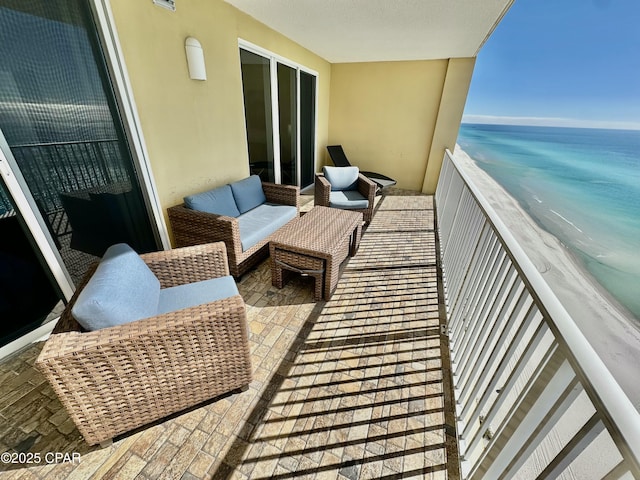 balcony featuring a beach view and a water view