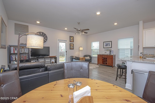 dining area featuring hardwood / wood-style flooring, sink, and ceiling fan