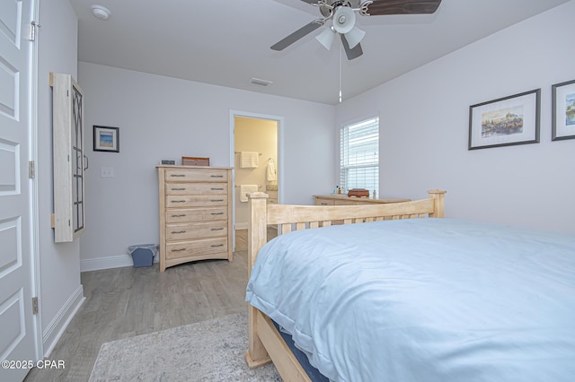 bedroom with ceiling fan, ensuite bathroom, and light hardwood / wood-style floors