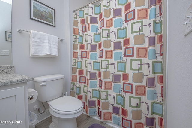 bathroom featuring vanity, toilet, curtained shower, and wood-type flooring