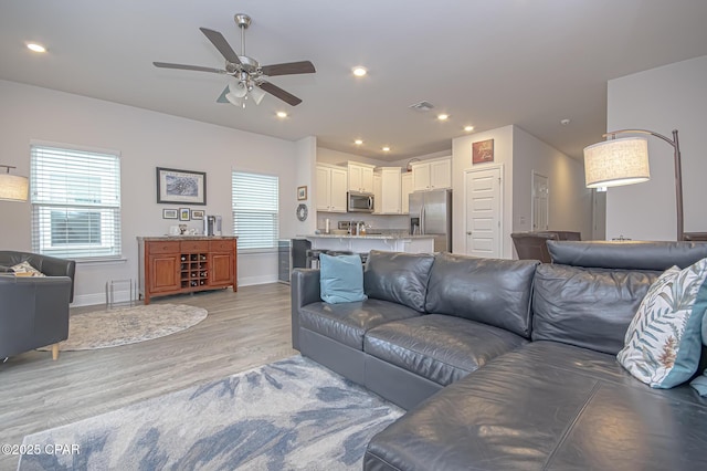 living room with ceiling fan, a healthy amount of sunlight, and light hardwood / wood-style floors