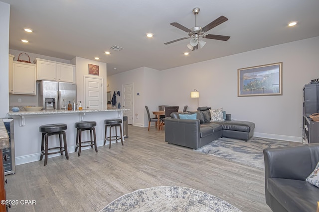 living room with ceiling fan and light hardwood / wood-style floors