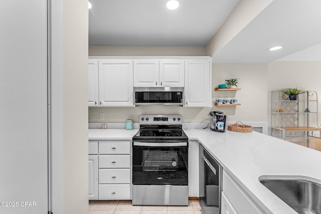 kitchen with light tile patterned flooring, appliances with stainless steel finishes, and white cabinets