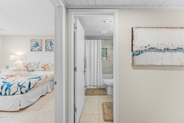 tiled bedroom featuring connected bathroom