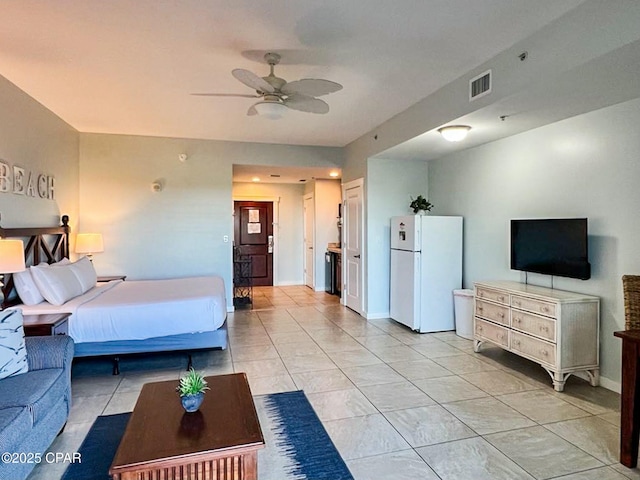 bedroom with light tile patterned floors, ceiling fan, and white refrigerator