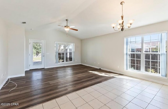 unfurnished living room featuring lofted ceiling, a healthy amount of sunlight, and ceiling fan with notable chandelier