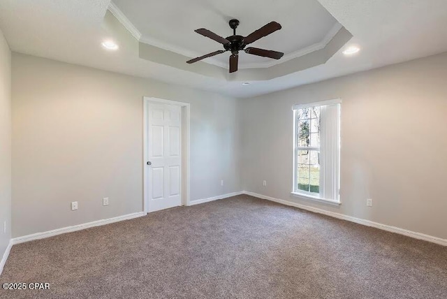 empty room featuring ceiling fan, crown molding, carpet floors, and a tray ceiling