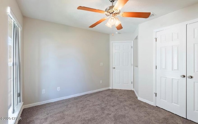 unfurnished bedroom with ceiling fan, light carpet, and a closet