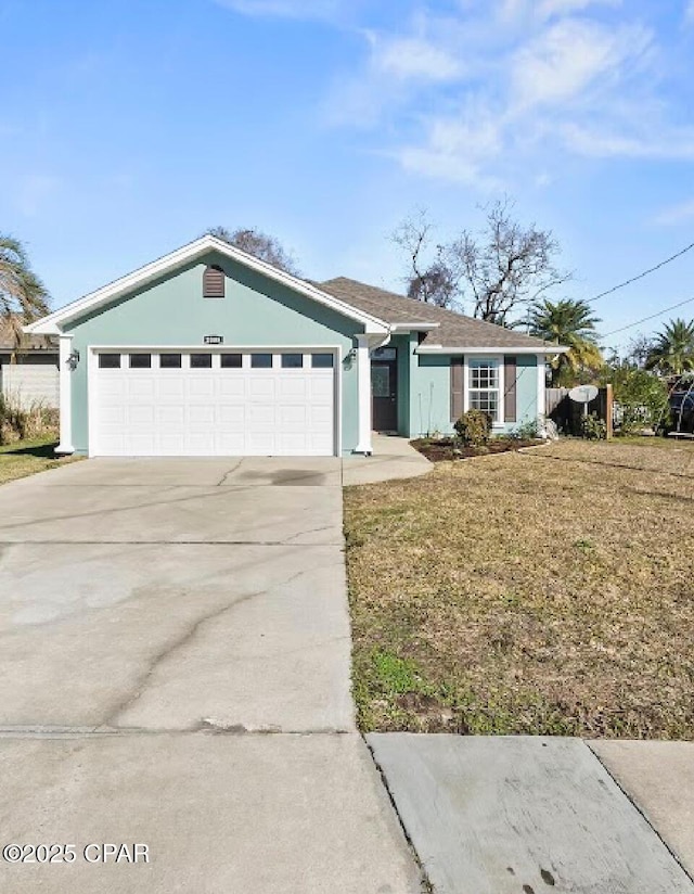 single story home featuring a garage and a front lawn