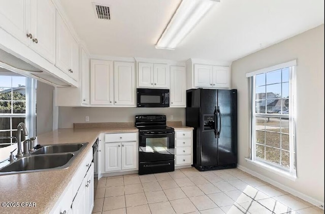 kitchen with a healthy amount of sunlight, white cabinetry, sink, and black appliances