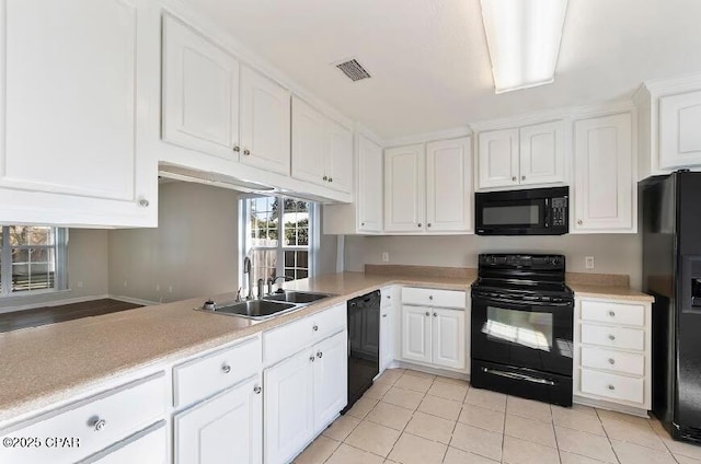 kitchen featuring black appliances, sink, white cabinetry, and light tile patterned flooring