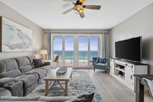 living room with ceiling fan and light hardwood / wood-style flooring