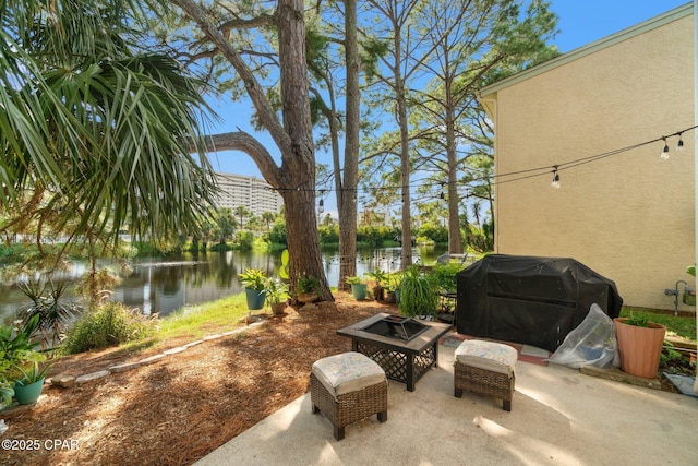 view of patio / terrace with a water view, grilling area, and a fire pit