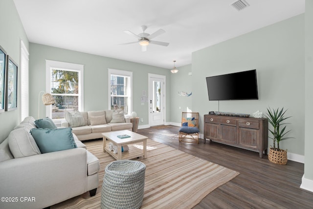 living room featuring ceiling fan and dark wood-type flooring