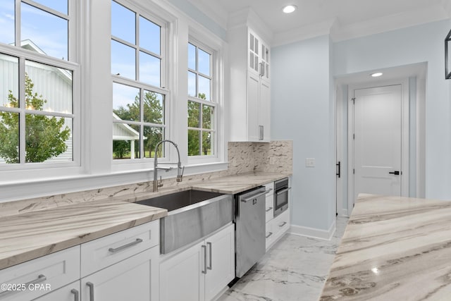 kitchen with light stone counters, white cabinets, appliances with stainless steel finishes, and sink