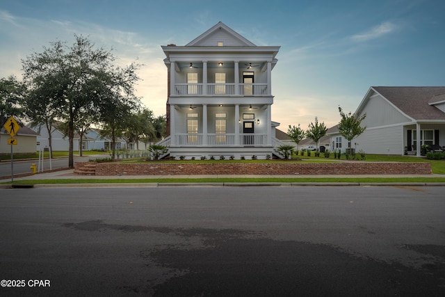 neoclassical / greek revival house featuring a balcony and a porch