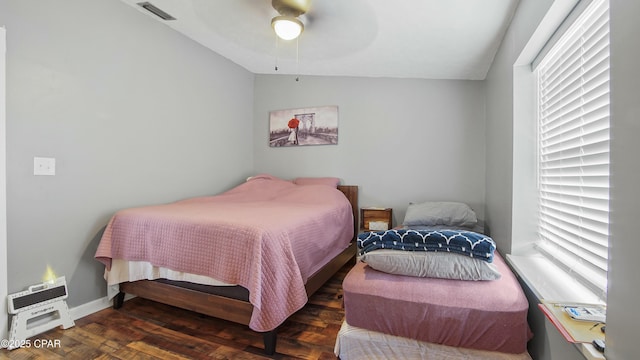 bedroom featuring ceiling fan, vaulted ceiling, dark hardwood / wood-style floors, and multiple windows