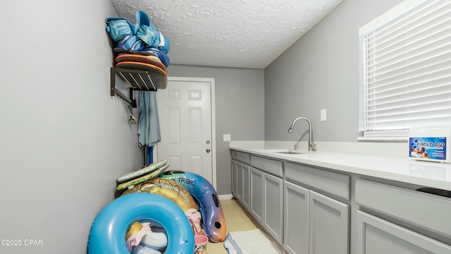 laundry room with sink and a textured ceiling