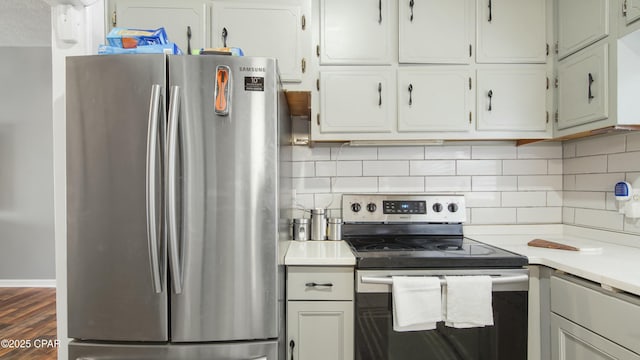 kitchen with dark wood-type flooring, white cabinets, backsplash, and appliances with stainless steel finishes