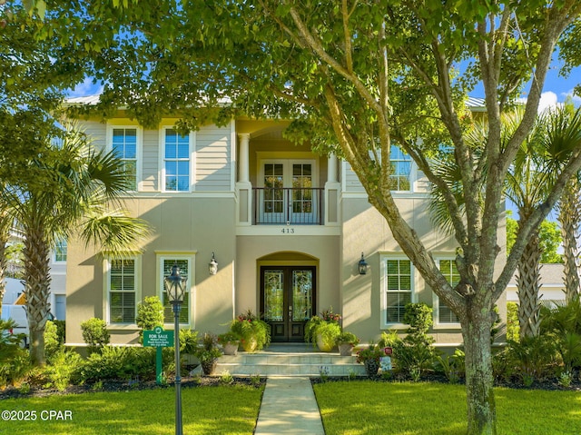 property entrance with french doors and a lawn