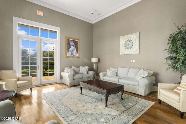 living room with french doors, hardwood / wood-style floors, and crown molding