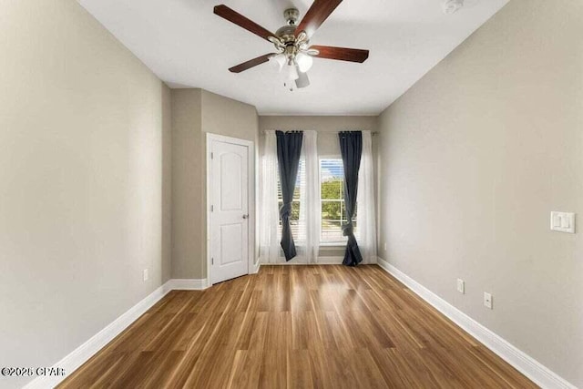 unfurnished room with ceiling fan and wood-type flooring