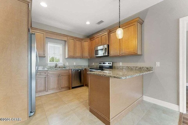 kitchen with stainless steel appliances, light stone countertops, kitchen peninsula, sink, and decorative light fixtures