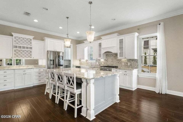 kitchen featuring decorative light fixtures, stainless steel fridge, a kitchen island, dark hardwood / wood-style flooring, and white cabinets