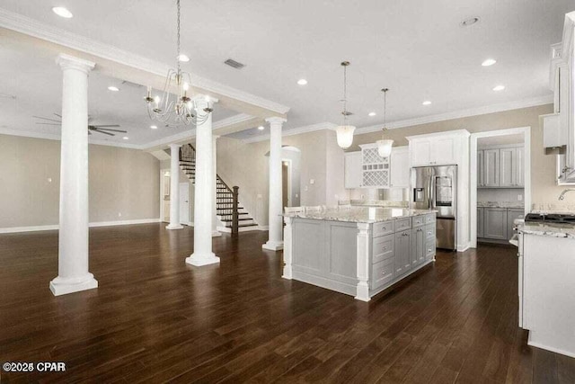 kitchen featuring stainless steel refrigerator with ice dispenser, a kitchen island, white cabinets, and hanging light fixtures