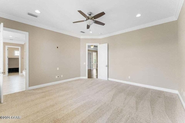 empty room with ceiling fan, light colored carpet, and crown molding