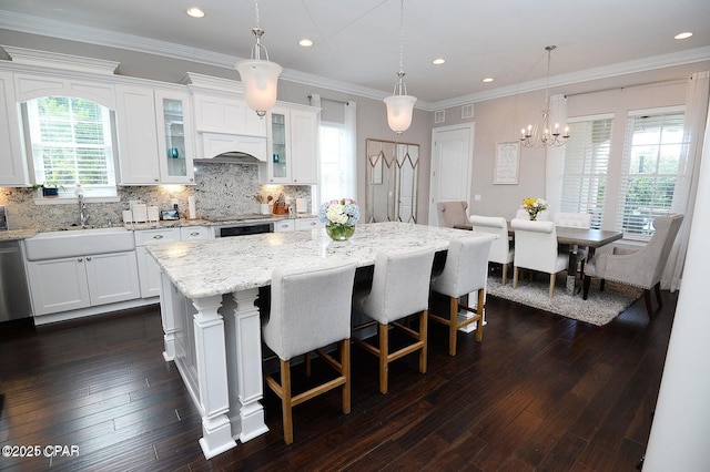 kitchen featuring sink, pendant lighting, white cabinetry, and a center island