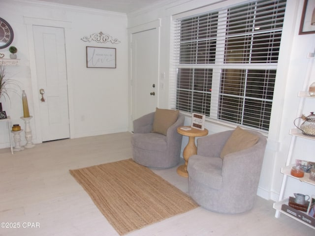 living area featuring crown molding and hardwood / wood-style flooring