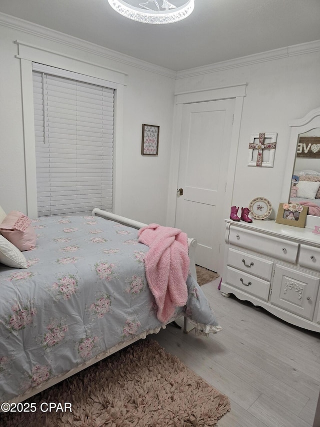 bedroom featuring crown molding and light wood-type flooring