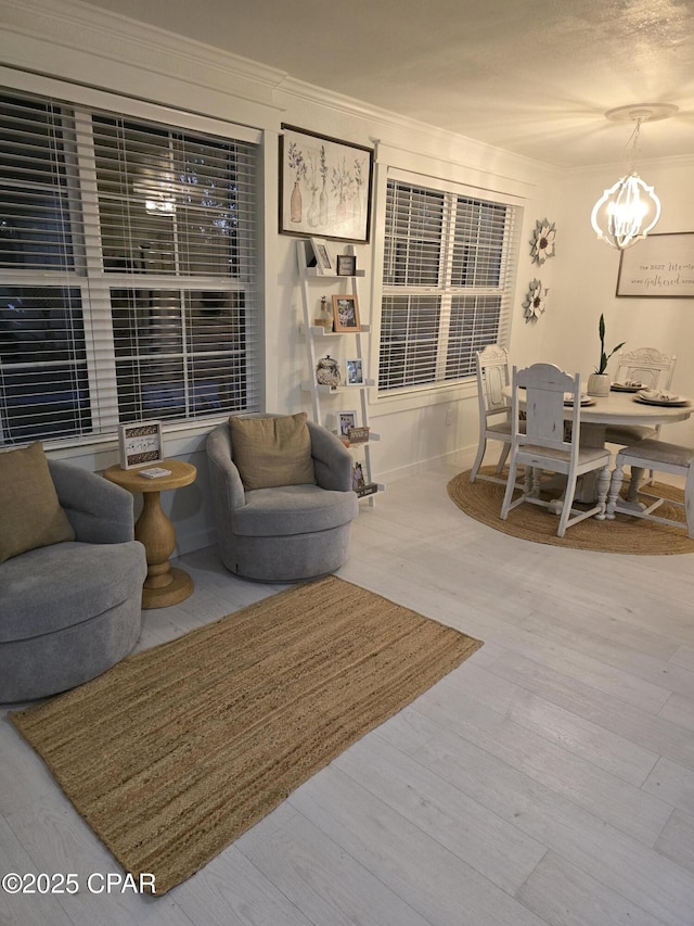 living room featuring crown molding, hardwood / wood-style floors, and a notable chandelier