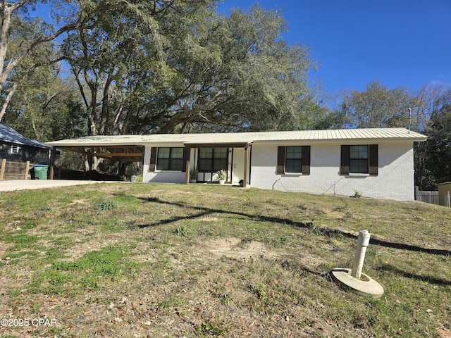 ranch-style home featuring a carport and a front yard