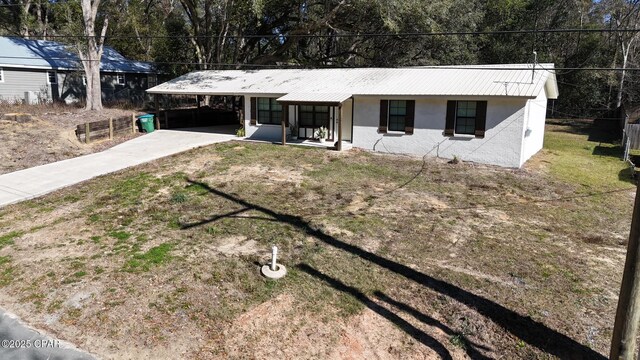 single story home with a front yard, a carport, and covered porch