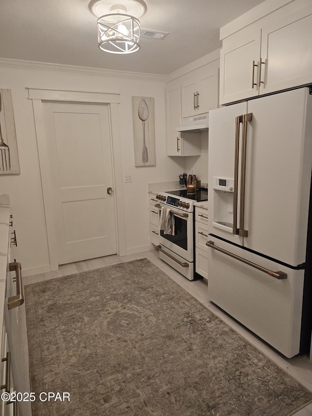 kitchen featuring white appliances, ornamental molding, light tile patterned floors, and white cabinets