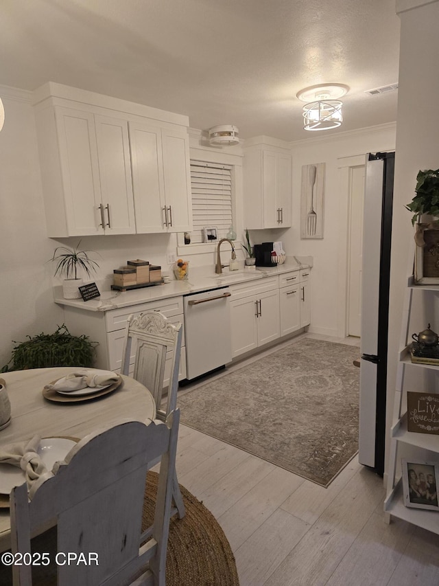 kitchen with refrigerator, sink, white cabinets, white dishwasher, and light wood-type flooring