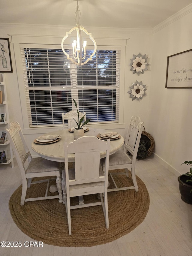 dining space with a notable chandelier, ornamental molding, and hardwood / wood-style floors